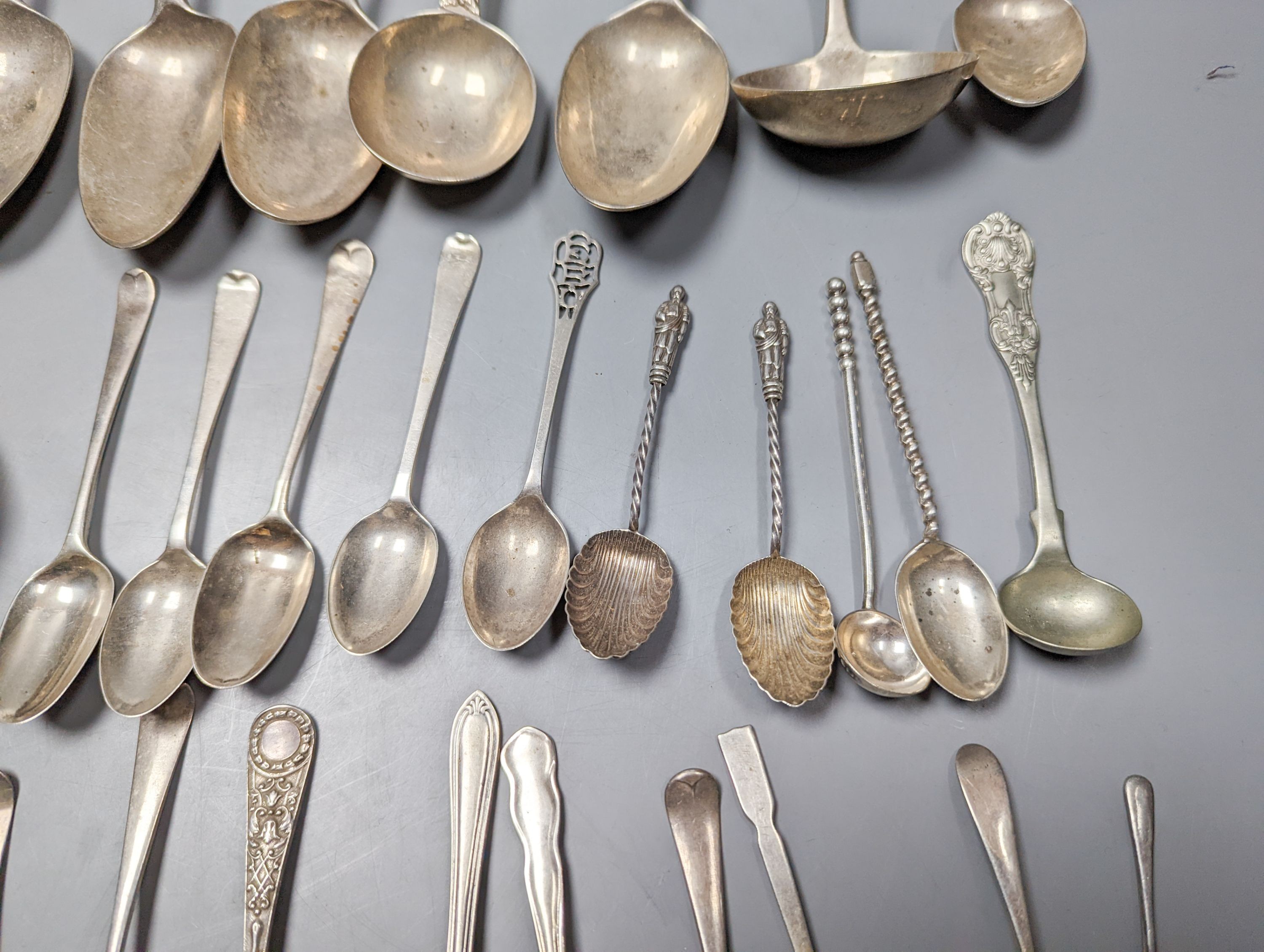 A mixed quantity of 18th, 19th and 20th century silver flatware, including tablespoons, teaspoons, sauce ladles, a 900 standard cake slice, two plated spoons and a nail implement